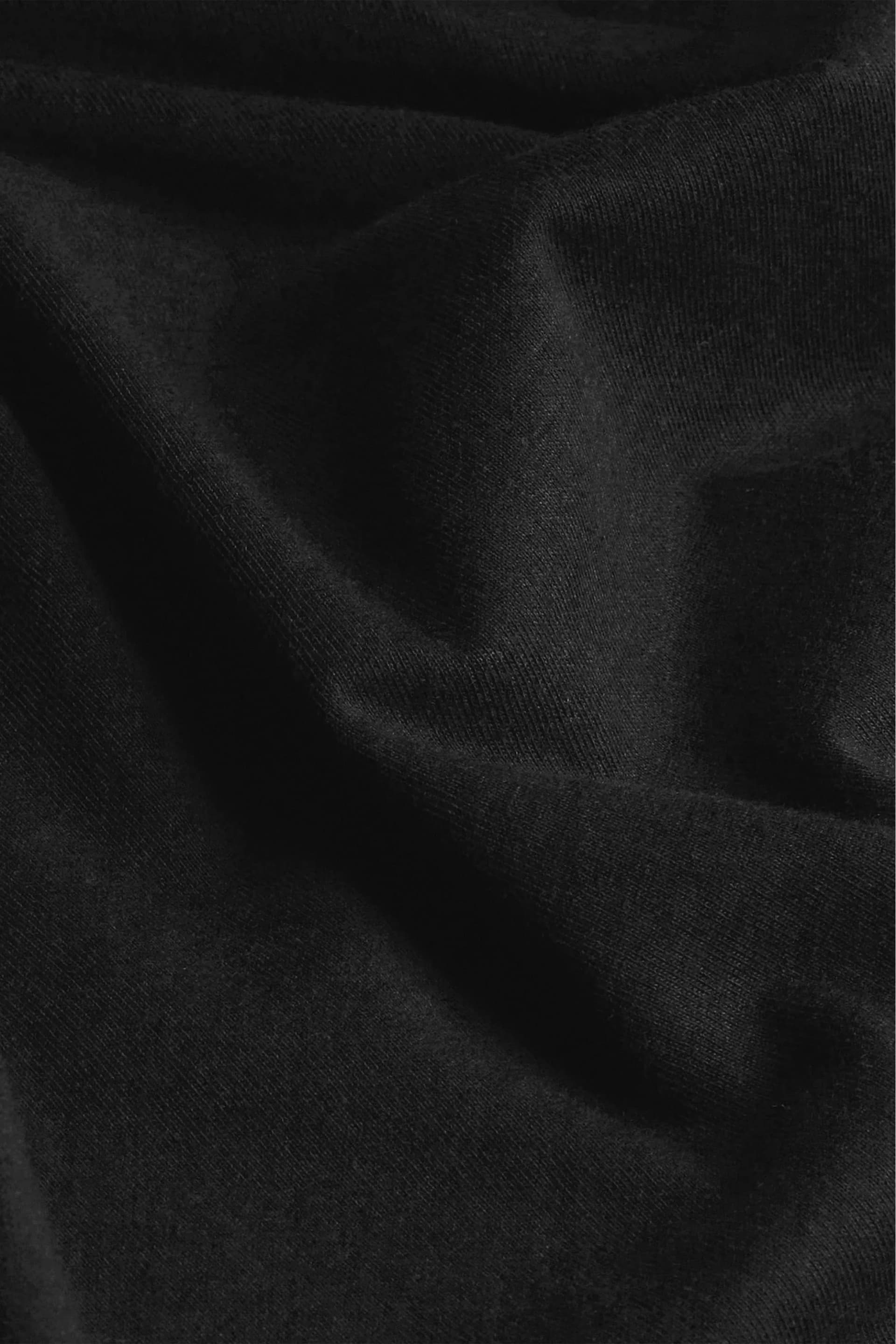 Detalhe do algodão puro da Camiseta Essencial Preta, maciez e durabilidade Textura do tecido em algodão 100% natural da Camiseta Essencial Preta